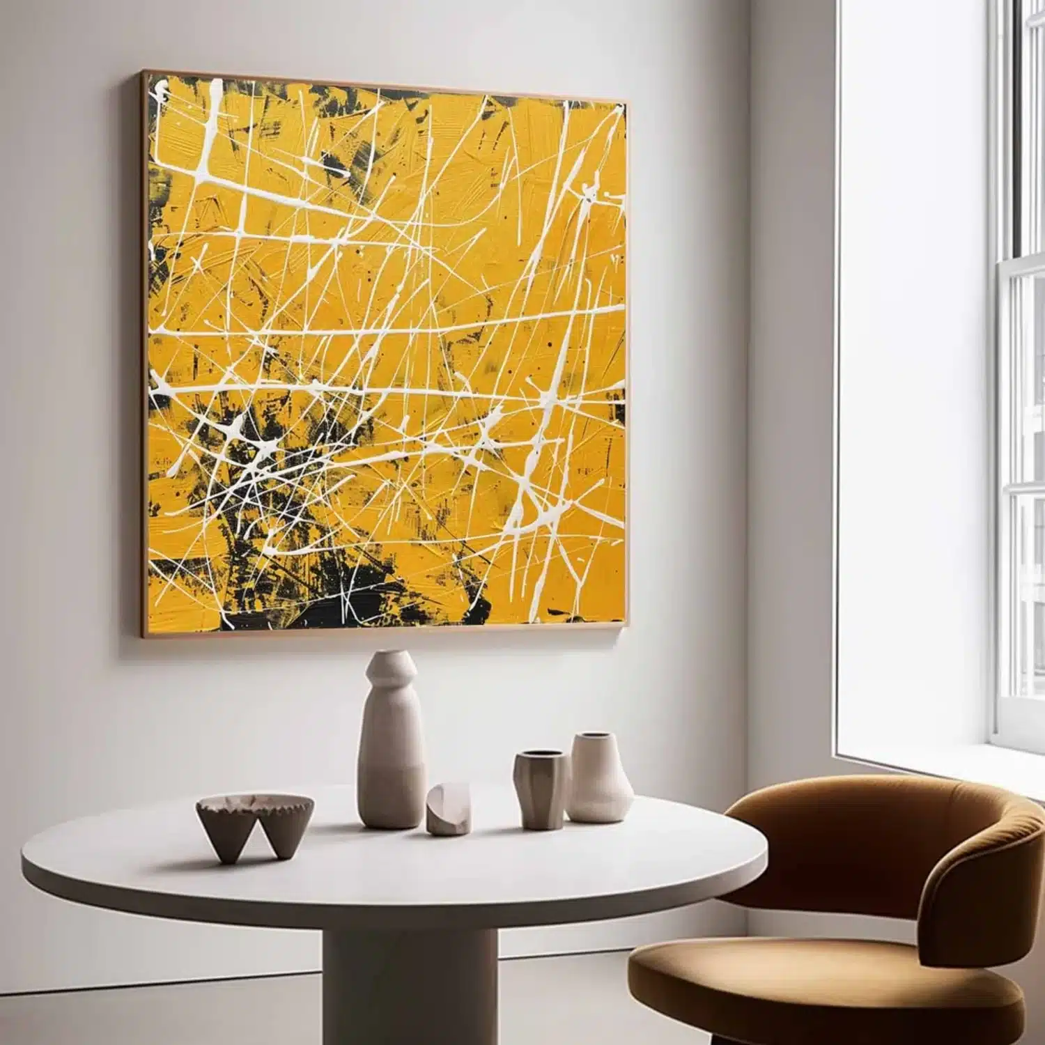 Square abstract painting featuring vibrant yellow textured impasto background with white linear splatters and black accents mounted above a round white dining table.